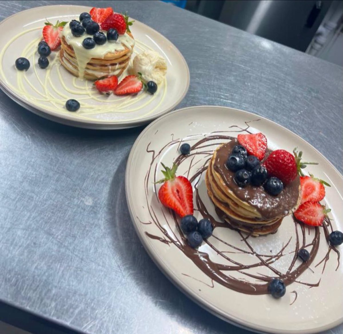 Two stacks of pancakes with berries